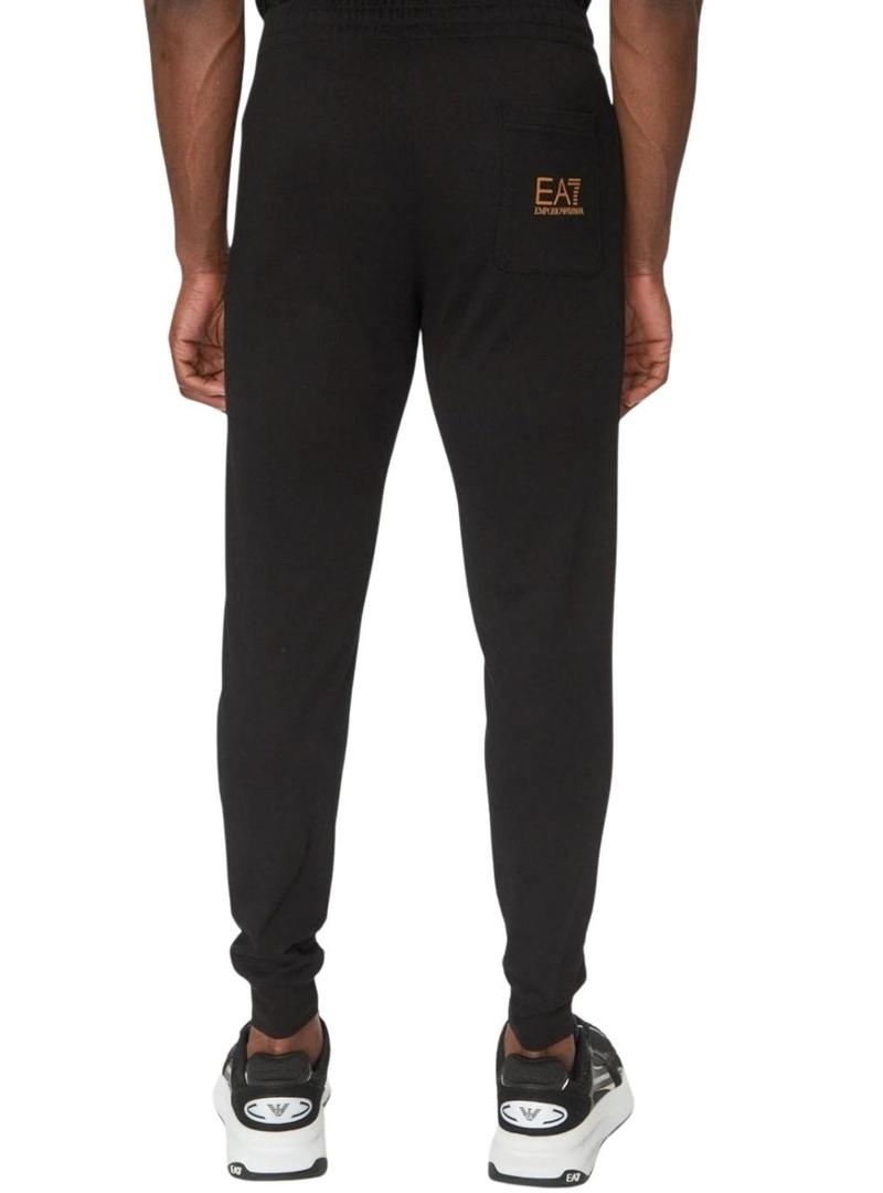 Calça Emporio Armani EA7 preta e dourada para homem.